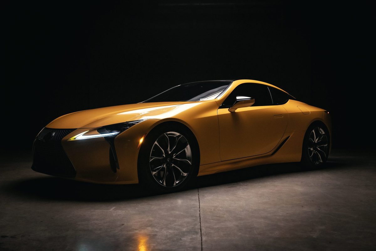 Yellow Lexus LC 500 in a dark studio, lit from the front